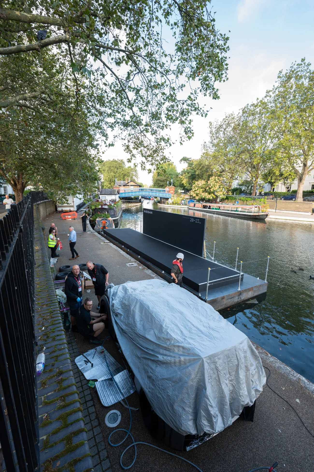 Production and marine crews preparing a floating launch stage beside the water