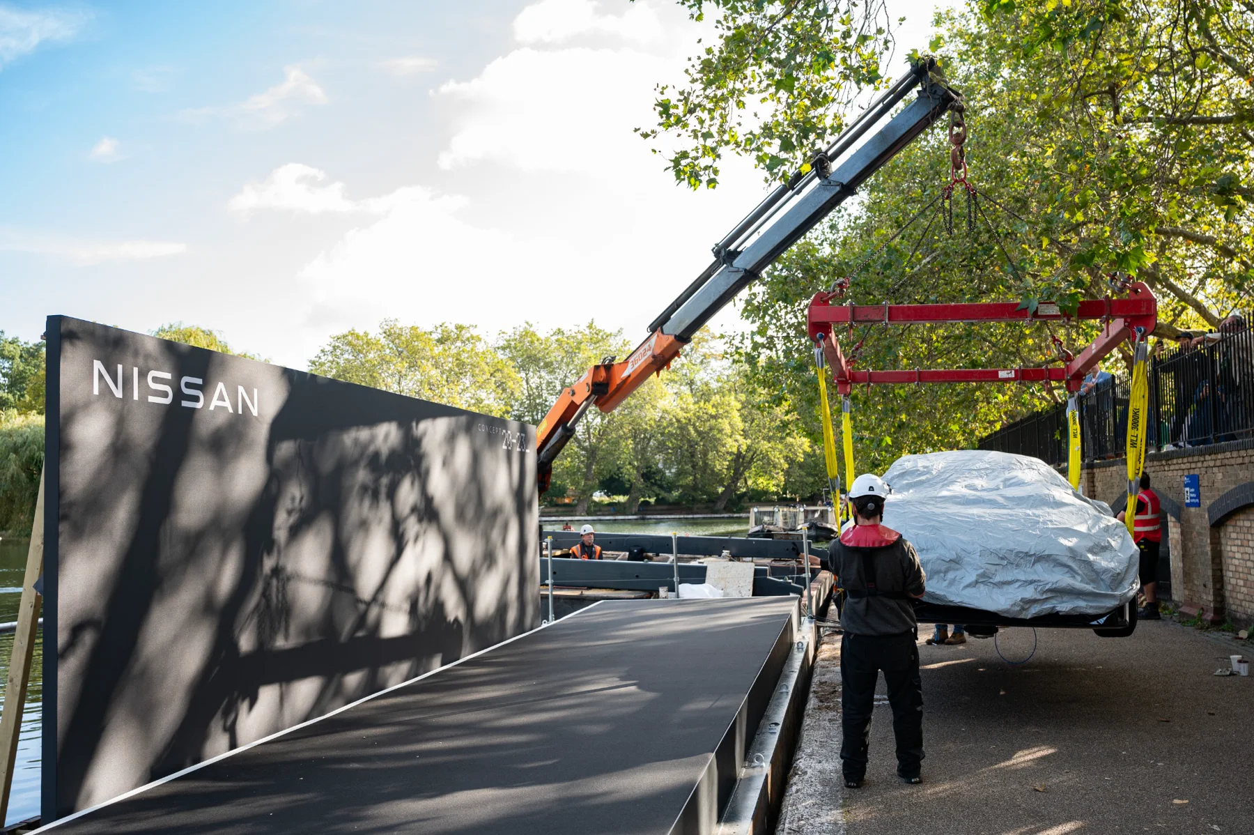 Crane and lifting frame transferring a covered vehicle onto the floating stage