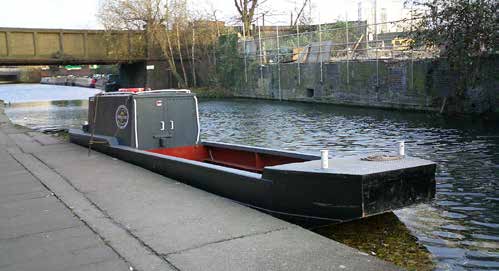 Cabined WHH motor workboat moored beside a towpath