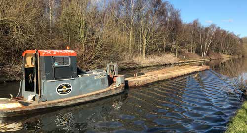 Narrow WHH hopper and tug working on a rural canal