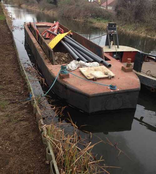 Small open WHH utility barge moored on a canal