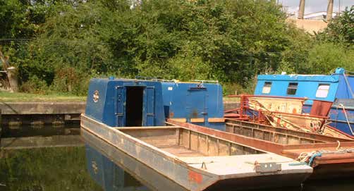 Small flat-decked WHH workboat on a canal