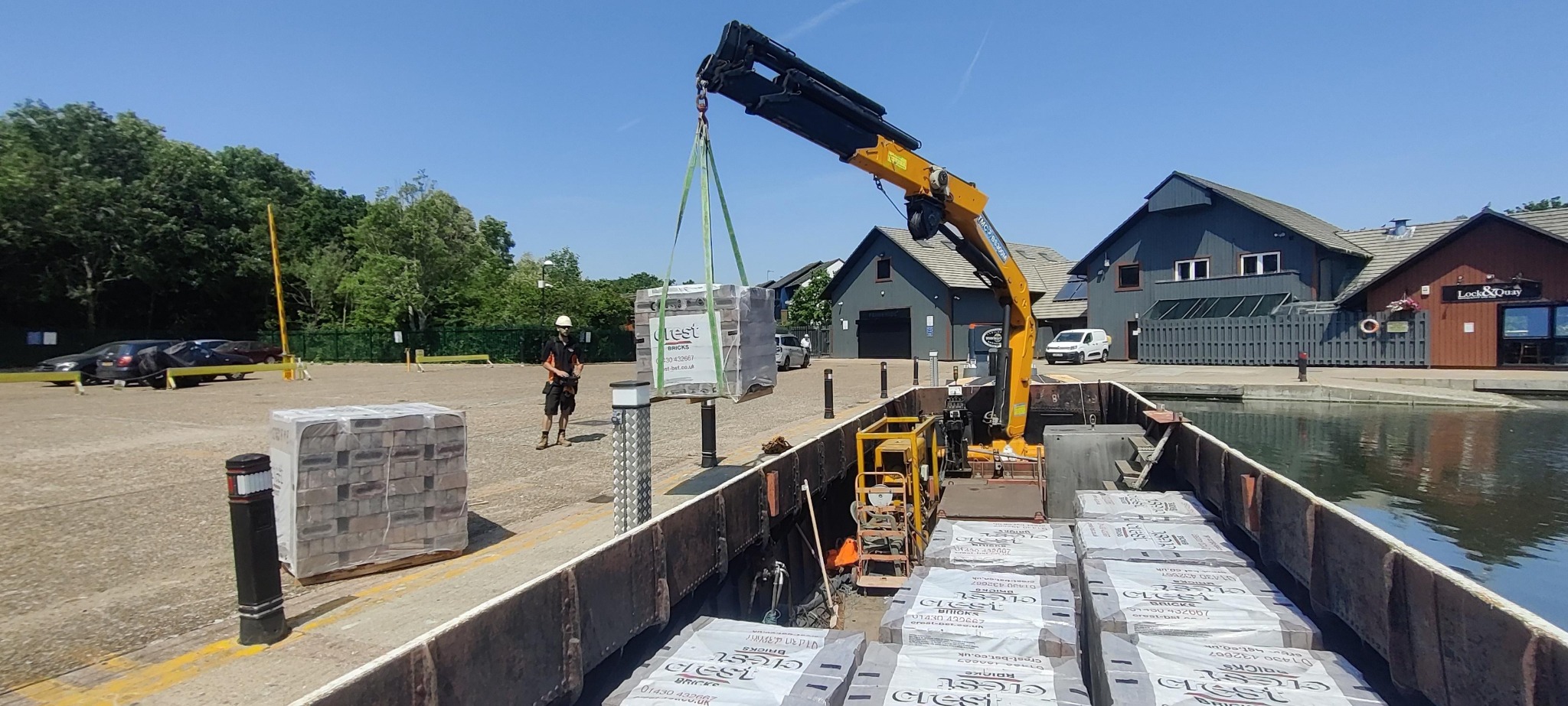 Bricks being lifted from a loaded WHH crane barge for delivery to a constrained construction site