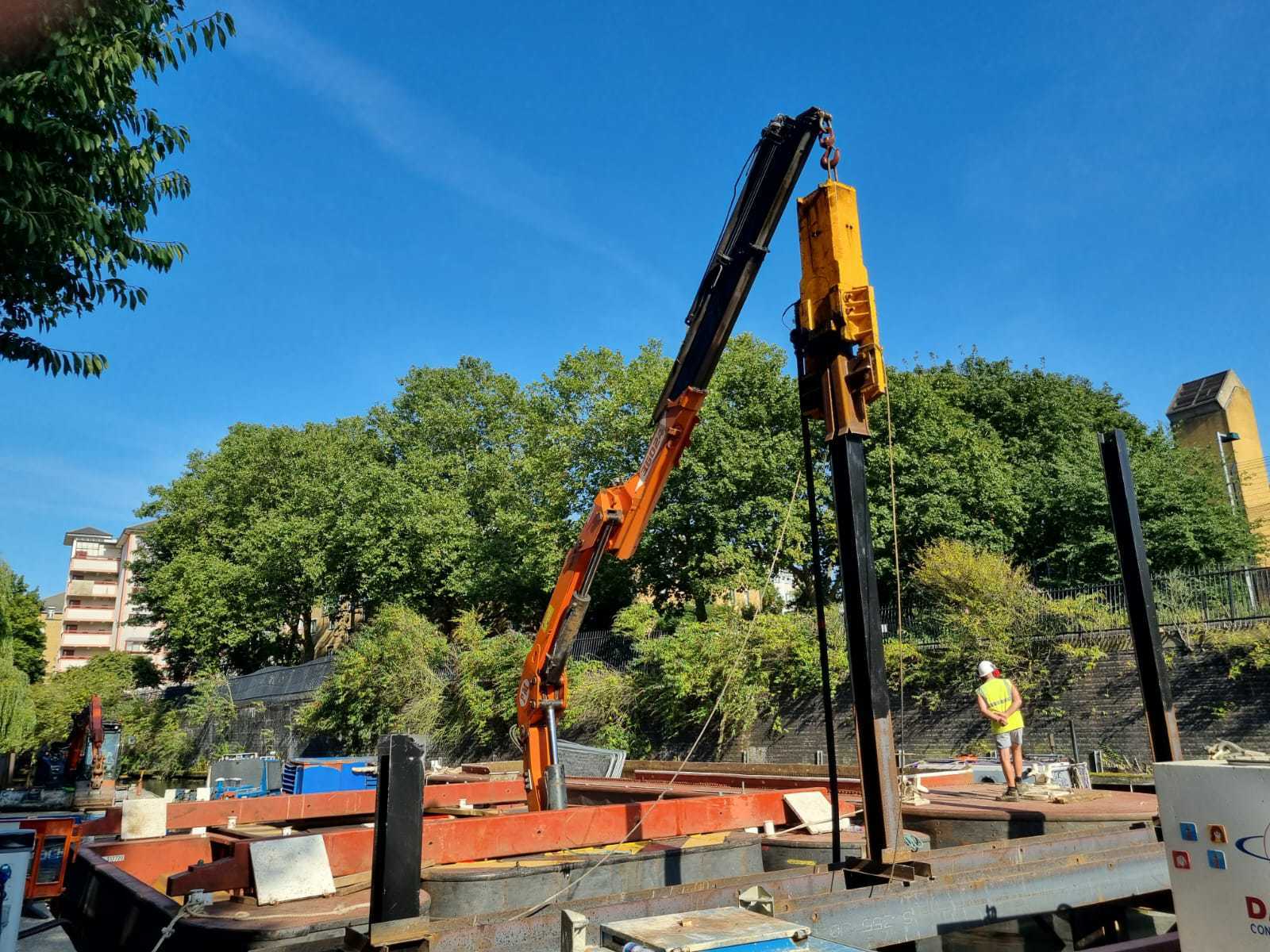 WHH crane barge supporting a piling operation on an urban canal