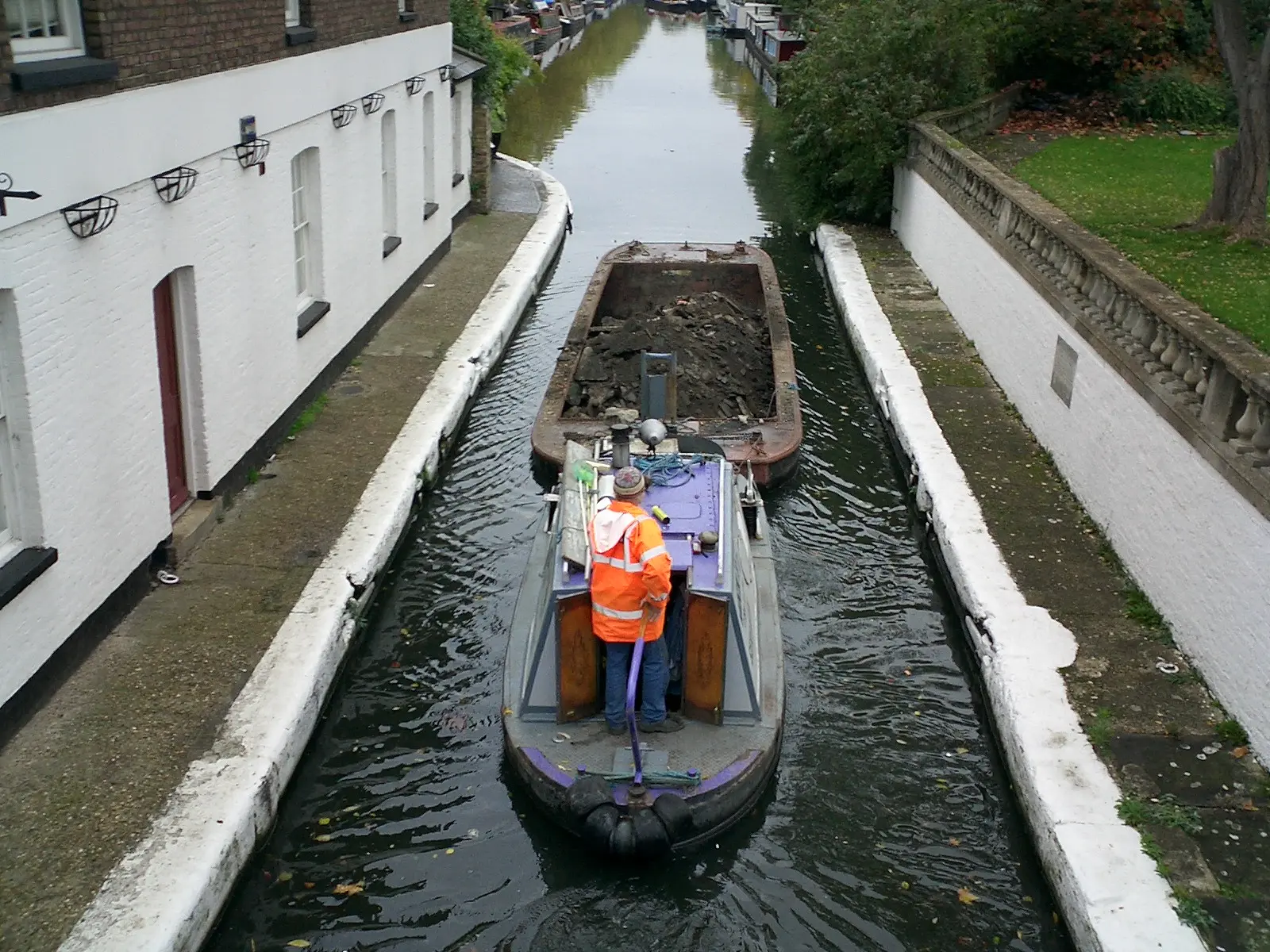 WHH tug moving the loaded excavation pan through the confined waterway at Little Venice