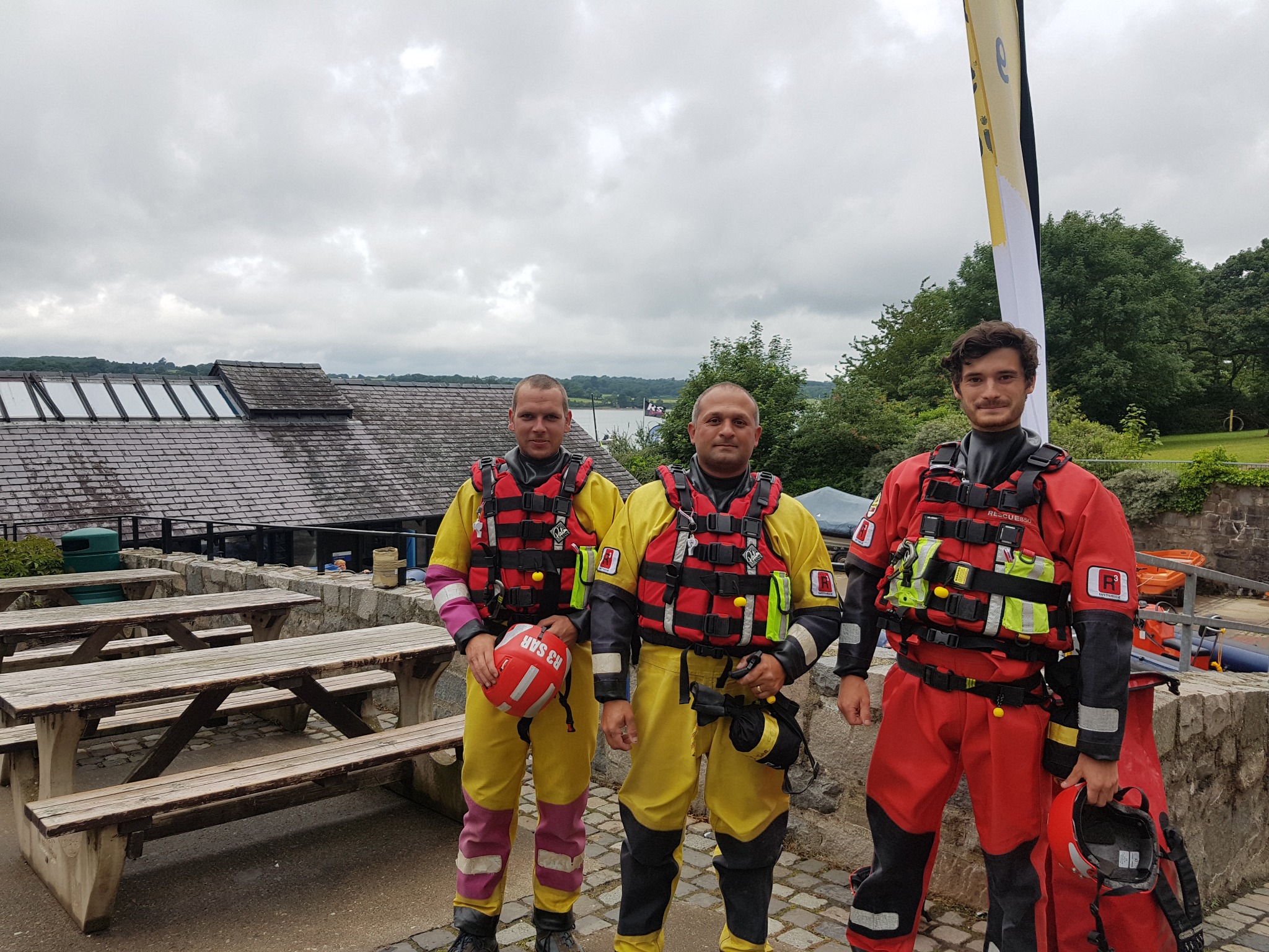 Water safety crew in protective equipment preparing beside a waterway