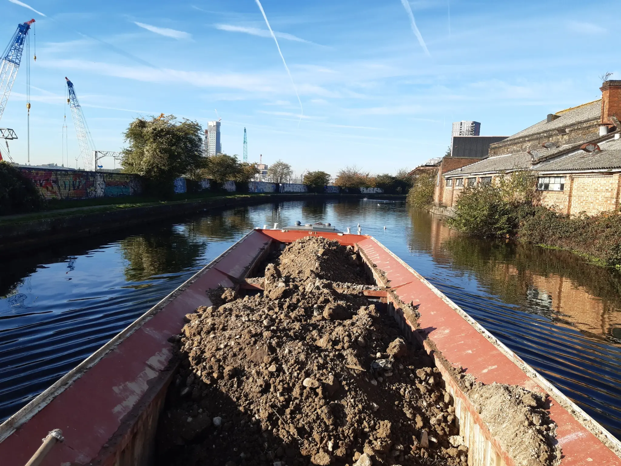 Loaded WHH hopper carrying excavated material by canal